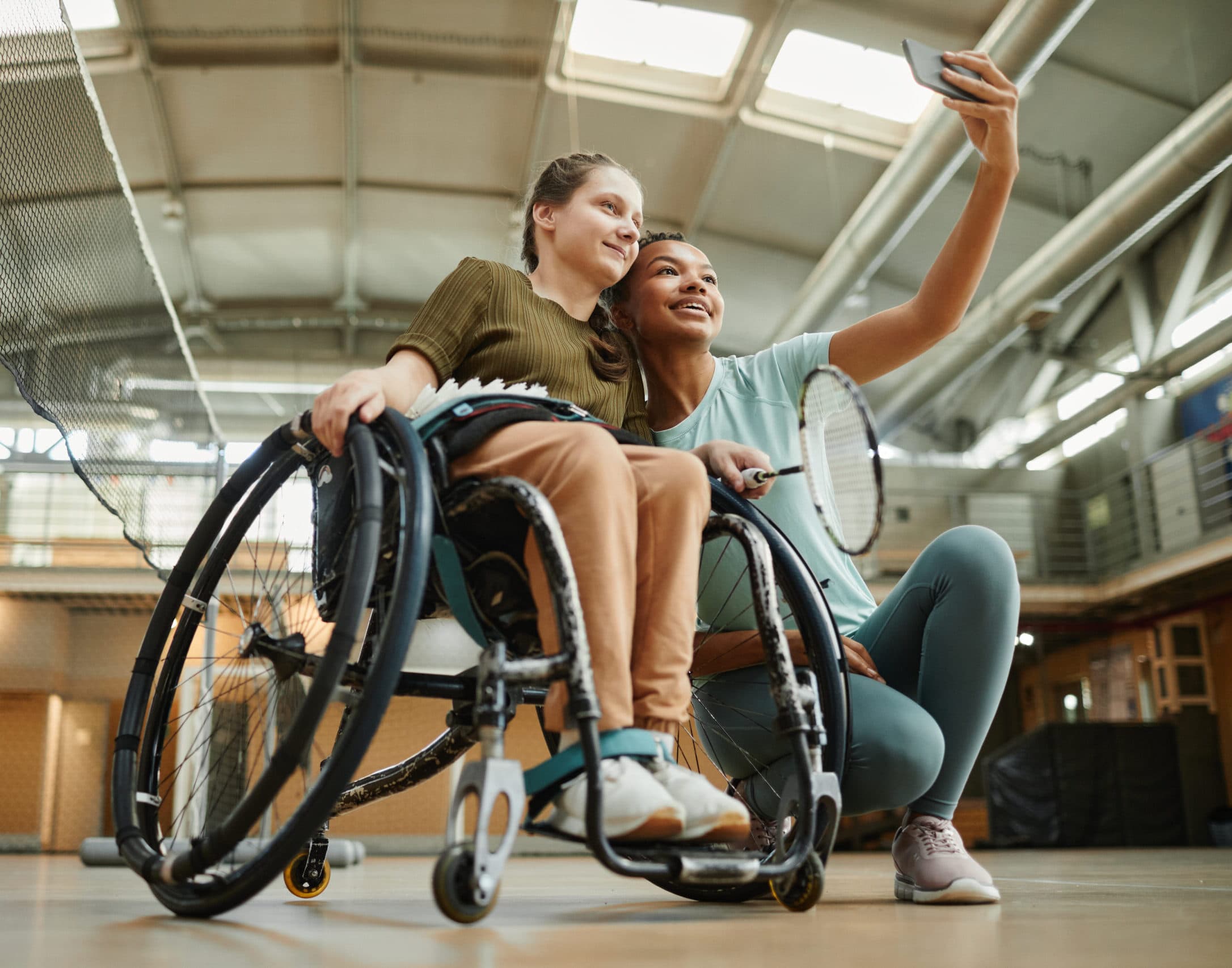 A young wheelchair user taking a selfie with a friend