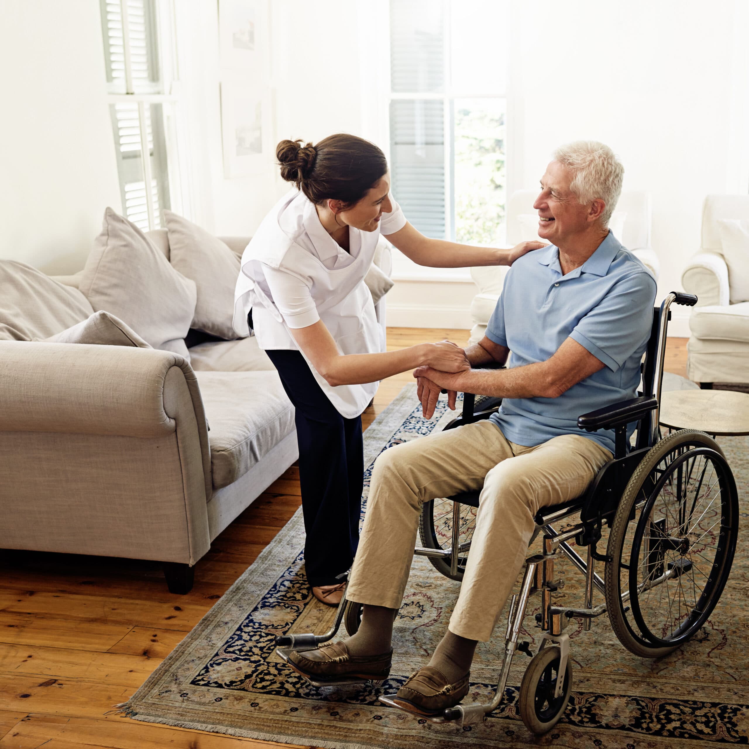 A carer helping an older man in a wheelchair at home