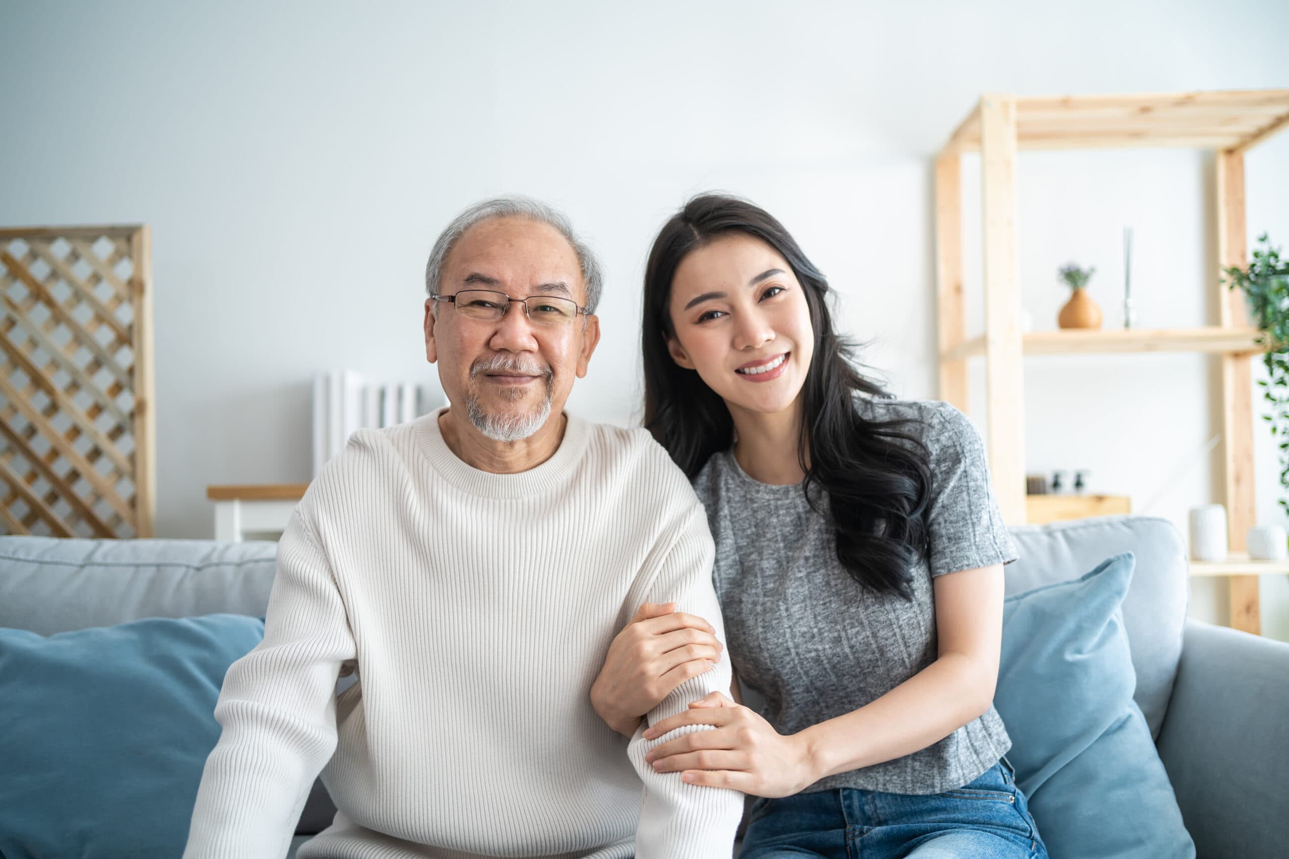 An older man and a younger woman sitting together at home