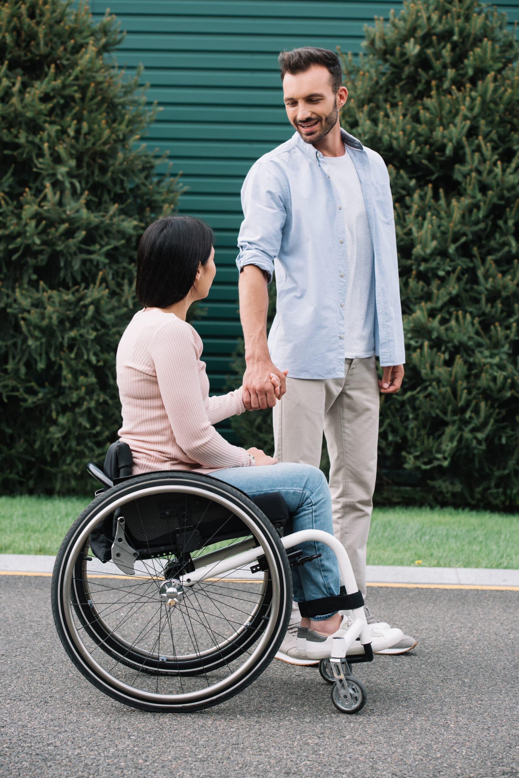 An NDIS support worker walking alongside a client in a community setting